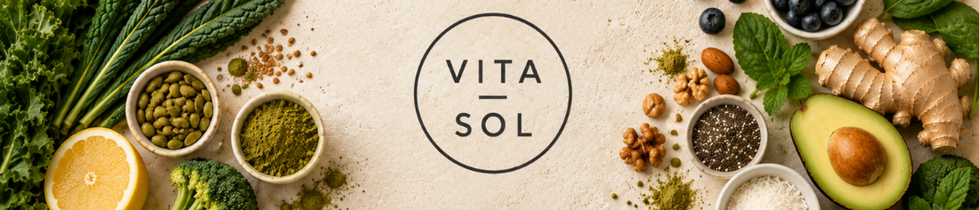 Fresh wholefood ingredients including leafy greens, avocado, lemon, ginger and seeds surrounding the Vita-Sol logo.